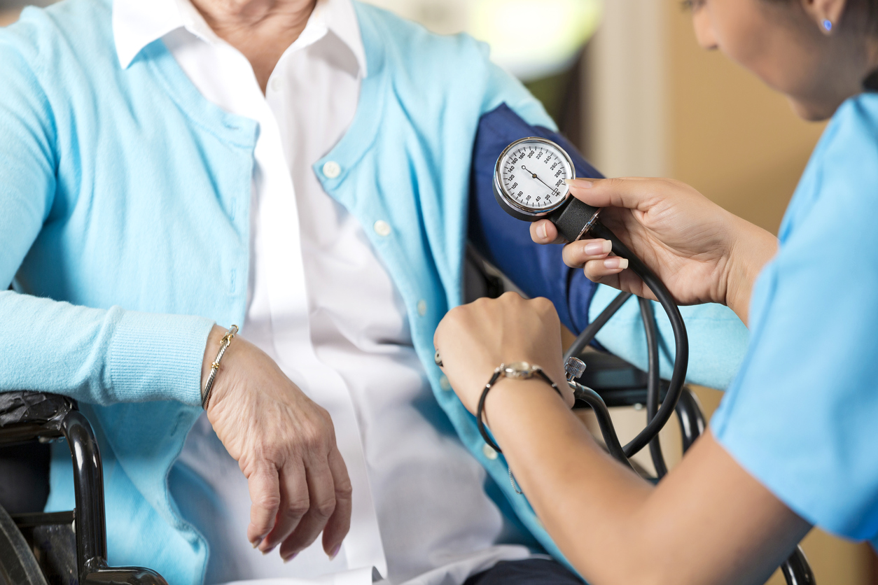 Senior woman in wheelchair getting her blood pressure taken